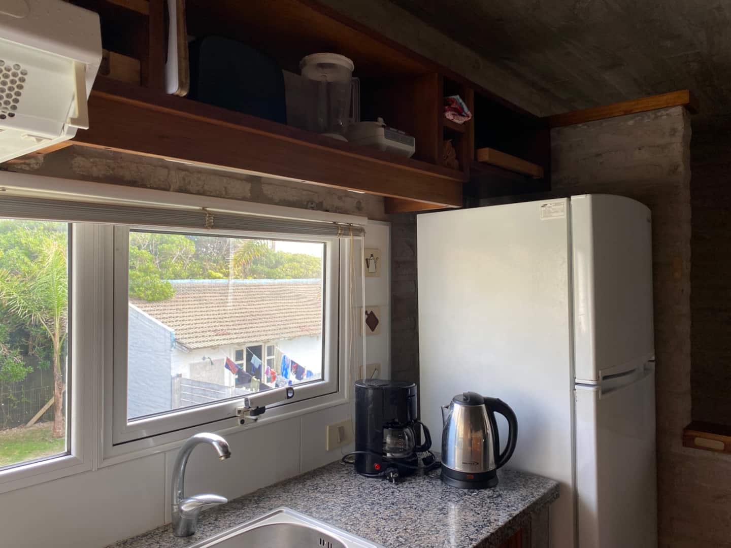 Cocina con heladera y ventana