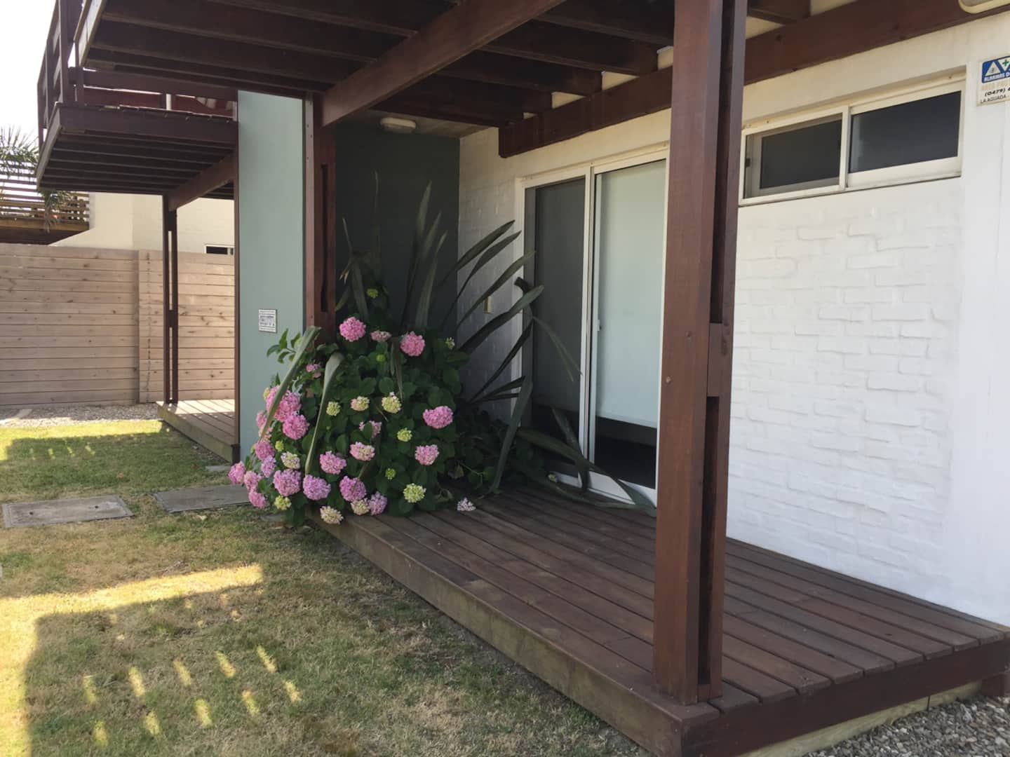 Deck de acceso al dormitorio con hortensias